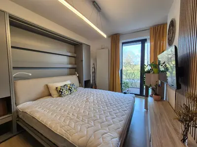 a bedroom with a large bed and a large window at Elegant City Apartment with Balcony near Center in Prague