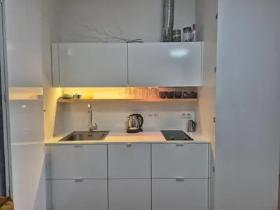 a small kitchen with white cabinets and a sink at Elegant City Apartment with Balcony near Center in Prague