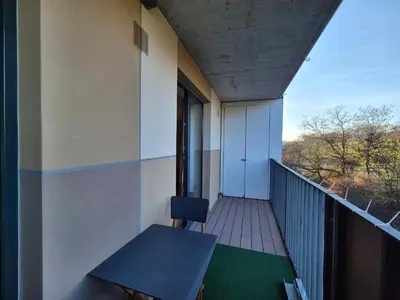 a balcony with a blue table and a chair at Elegant City Apartment with Balcony near Center in Prague