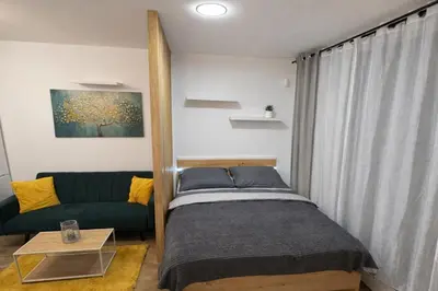 a small bedroom with a bed and a couch at Stylish Studio with Private Hot Tub & Terrace in Prague