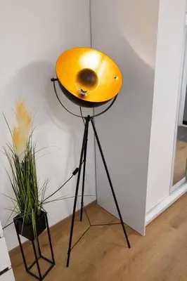 a yellow lamp on a stand next to a wall at Stylish Studio with Private Hot Tub & Terrace in Prague