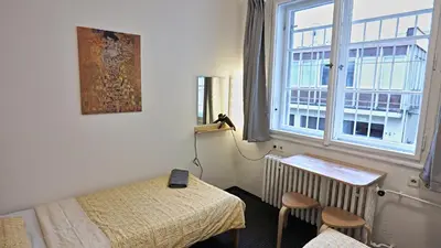 a room with two beds and a painting on the wall at Station Stay Rooms near Main Train Station in Prague