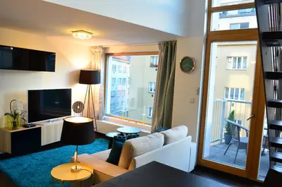 a living room with a couch and a large window at Apartments Palmovka in Prague