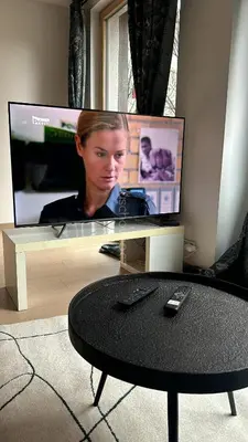 a television with a woman on the screen and a table at Apartments Palmovka in Prague