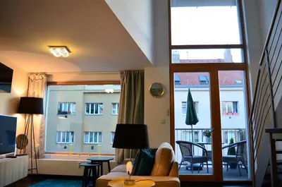 a living room with a couch and a large window at Apartments Palmovka in Prague
