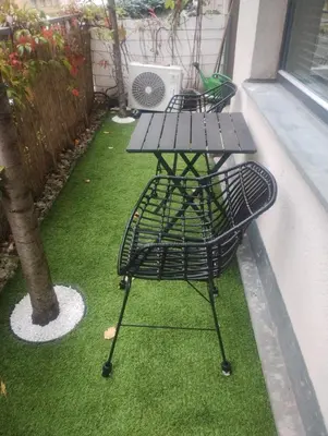 a picnic table on a balcony with a bird on it at Apartments Palmovka in Prague