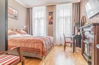 a bedroom with a bed and a desk and a chair at Elegant Prague Center Studio - Historic Building in Prague