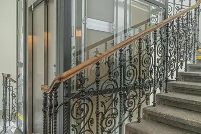 a staircase with a wrought iron railing and a glass door at Elegant Prague Center Studio - Historic Building in Prague