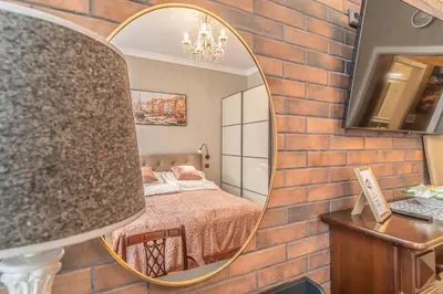 a bedroom with a brick wall and a mirror at Elegant Prague Center Studio - Historic Building in Prague