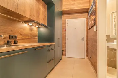 a kitchen with blue cabinets and a white door at Elegant Prague Center Studio - Historic Building in Prague