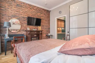 a bedroom with a bed and a desk and a television at Elegant Prague Center Studio - Historic Building in Prague
