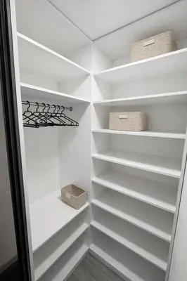 a walk in closet with white shelves and a box at Luxury 2BR Apartment Best Location Prague in Prague