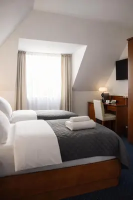 a bedroom with a large bed with a painting on the wall at Pawlovnia Hotel in Prague