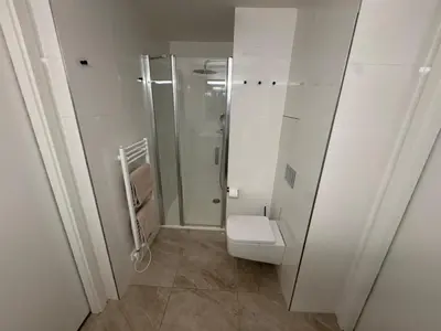 a white bathroom with a toilet and a shower at The Urban Nest - Grand Residence in Prague