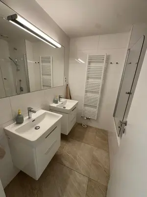 a white bathroom with two sinks and a mirror at The Urban Nest - Grand Residence in Prague