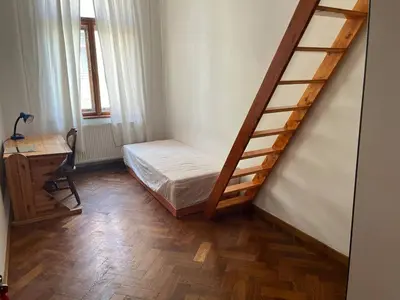 a bedroom with a bed and a wooden staircase at Central cozy rooms Soukenická S35 in Prague
