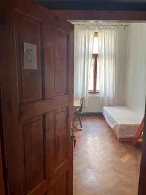 a bedroom with a wooden door with a bed and a window at Central cozy rooms Soukenická S35 in Prague