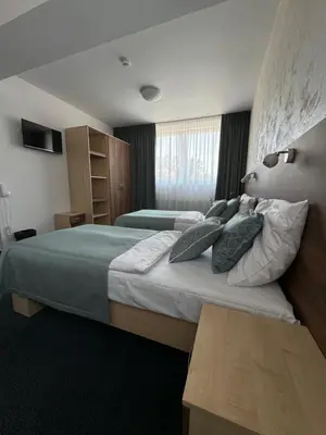 a hotel room with two beds and a window at Sport hotel Sletiště in Kladno