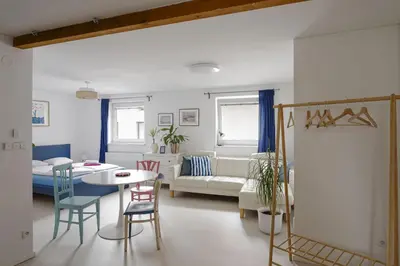 a living room with a table and a couch at Tichý byt blízko Pražského hradu in Prague