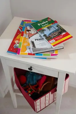 a white table with a pile of magazines on top of it at Tichý byt blízko Pražského hradu in Prague