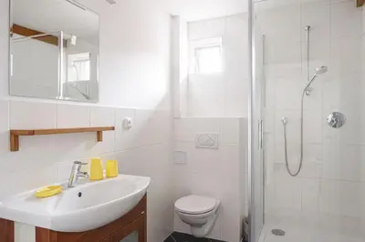 a white bathroom with a sink and a shower at Tichý byt blízko Pražského hradu in Prague