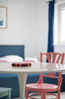 a white table with two red chairs around it at Tichý byt blízko Pražského hradu in Prague