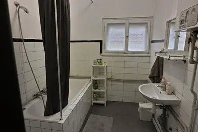 a bathroom with a bath tub and a sink at Prague Family Guest House - Rooms with shared bathroom in Prague