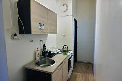 a small kitchen with a sink and a counter at Prague Family Guest House - Rooms with shared bathroom in Prague