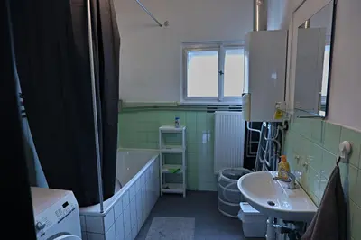 a bathroom with a tub and a sink and a toilet at Prague Family Guest House - Rooms with shared bathroom in Prague