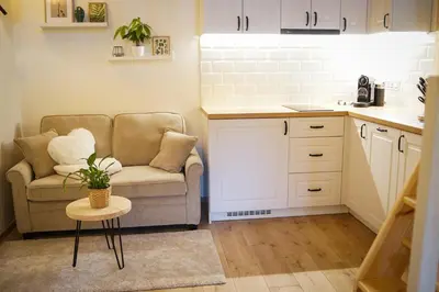 a kitchen with a couch and a table in a room at Wellness Chata Trvalka in Píkovice