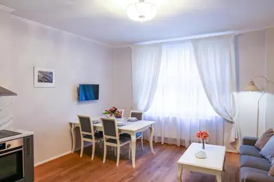 a living room with a table and a couch at White & Gray Apartments in Prague