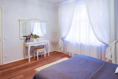 a bedroom with a bed and a table with a mirror at White & Gray Apartments in Prague