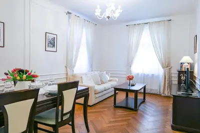 a living room with a table and a couch at White & Gray Apartments in Prague