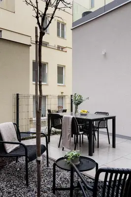 a patio with a table and chairs and a tree at U Zvonu Deluxe Apartments with Self Check-in in Prague