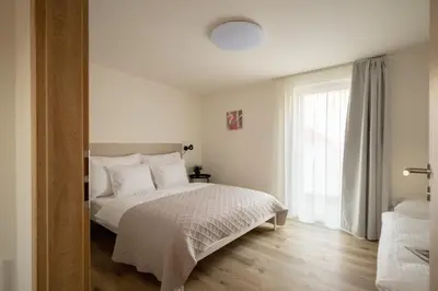 a white bedroom with a bed and a window at U Zvonu Deluxe Apartments with Self Check-in in Prague