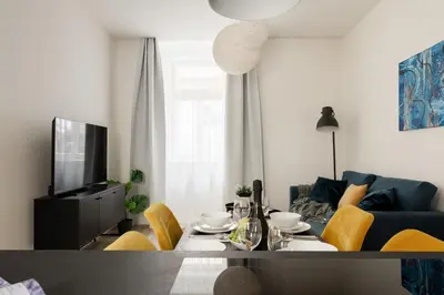 a living room with a table and yellow chairs at U Zvonu Deluxe Apartments with Self Check-in in Prague