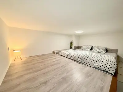 a bedroom with a bed and a wooden floor at Modern New Town Studio Heart of the City in Prague