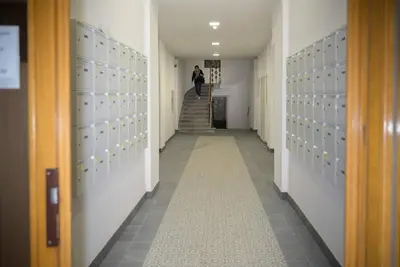 a hallway with lockers and a person walking down the aisle at Modern New Town Studio Heart of the City in Prague