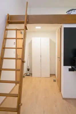 a loft bed with a ladder in a room at Modern New Town Studio Heart of the City in Prague