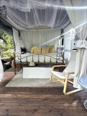 a bed in a tent with two chairs in a room at Chatička Anička or Garden 77 in Prague