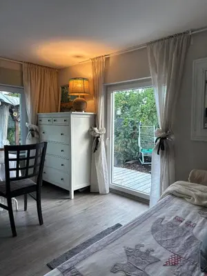a bedroom with a bed and a dresser and a window at Chatička Anička or Garden 77 in Prague