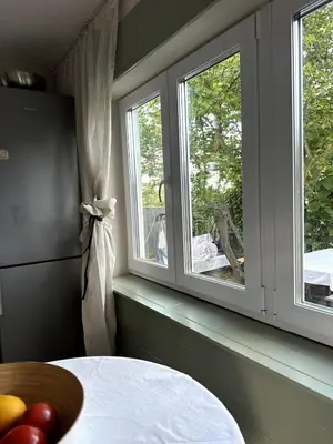 a room with two windows and a table with fruit on it at Chatička Anička or Garden 77 in Prague