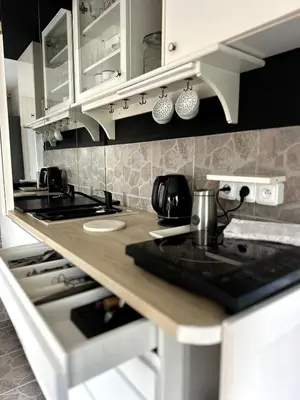 a kitchen with white cabinets and a stove top oven at Chatička Anička or Garden 77 in Prague
