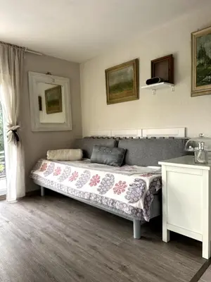 a bedroom with a bed and a table and a window at Chatička Anička or Garden 77 in Prague