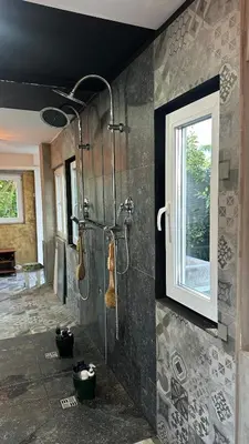 a bathroom with a shower with a window at Chatička Anička or Garden 77 in Prague