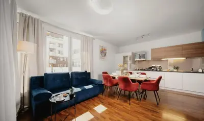 a living room with a blue couch and a table at COZY&DELUX Family apartment 3 min from Metro in Prague