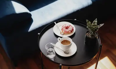 a table with a cup of coffee and a pastry at COZY&DELUX Family apartment 3 min from Metro in Prague