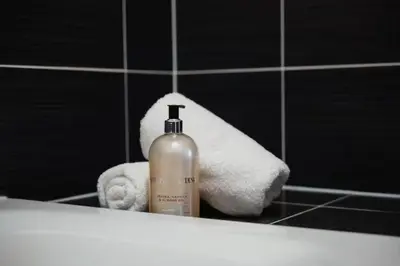 a towel and a bottle of soap in a bathroom mirror at COZY&DELUX Family apartment 3 min from Metro in Prague