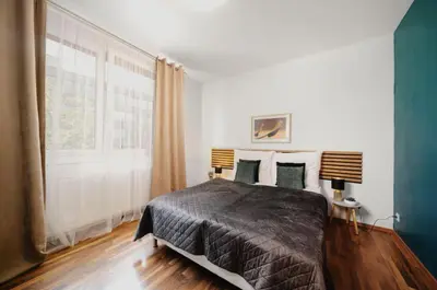 a bedroom with a bed and a large window at COZY&DELUX Family apartment 3 min from Metro in Prague
