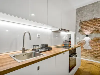 a kitchen with a sink and a brick wall at Design Spacy Apartman by City Center in Prague